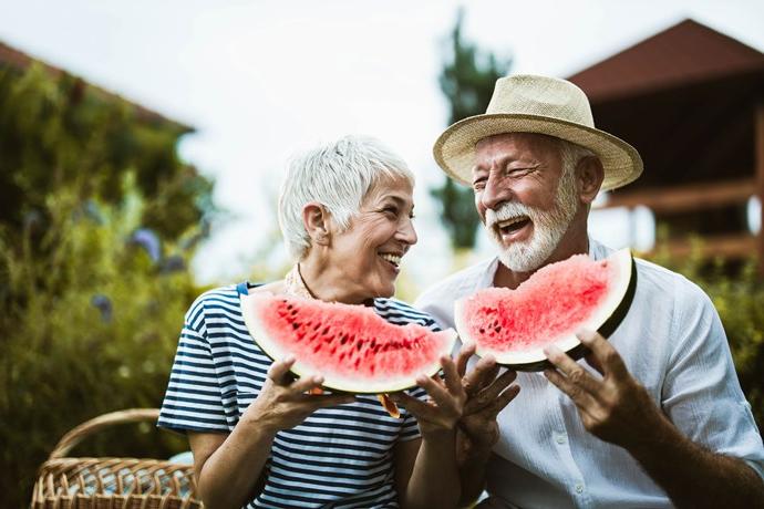 An older couple eating watermelon